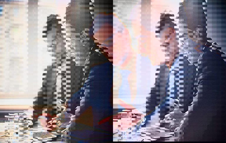 Two executives conversing over something on a tablet