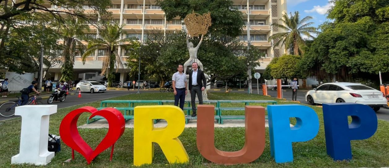 Professor Andrew Delios standing in front of RUPP sign